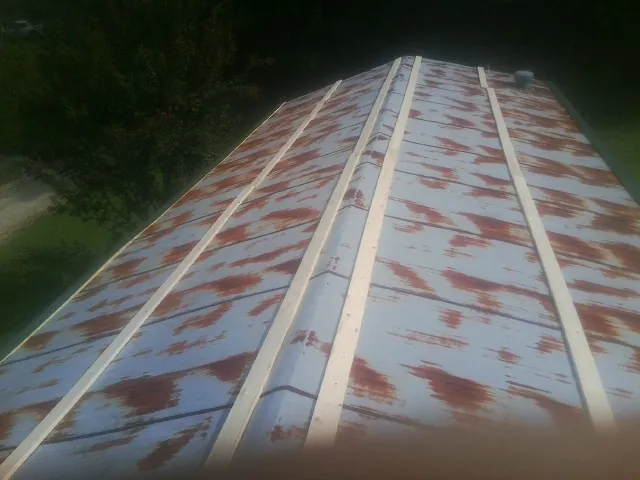 Rusted metal roof panels with new wood purlins before replacement — Storm Damage Roof Repair in Hannibal by Roofing Brothers