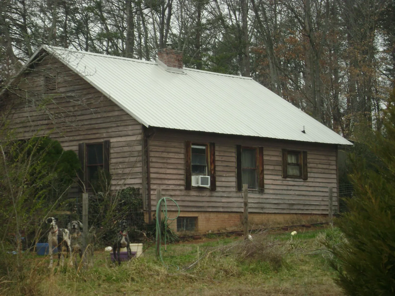 White metal roof on an old wood sided farmhouse, from a Metal Roof Installation job in Hannibal